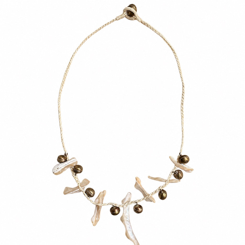 Pearl white coastal bohemian necklace with irregular shell-inspired pieces, bronze-tone bells, and cream braided cord by Browniecherry
